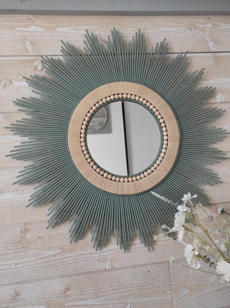 Miroir rond en bois naturel teinté d’un vert tendance, d’un bord en raphia et de perles de bois Ju0217