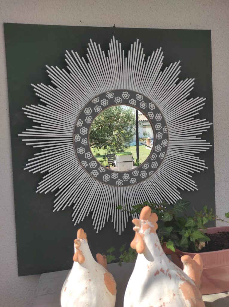 Miroir rond en bois teinté de blanc, cerné d'un bord en bois gris et embossé de petites fleurs Ju0179