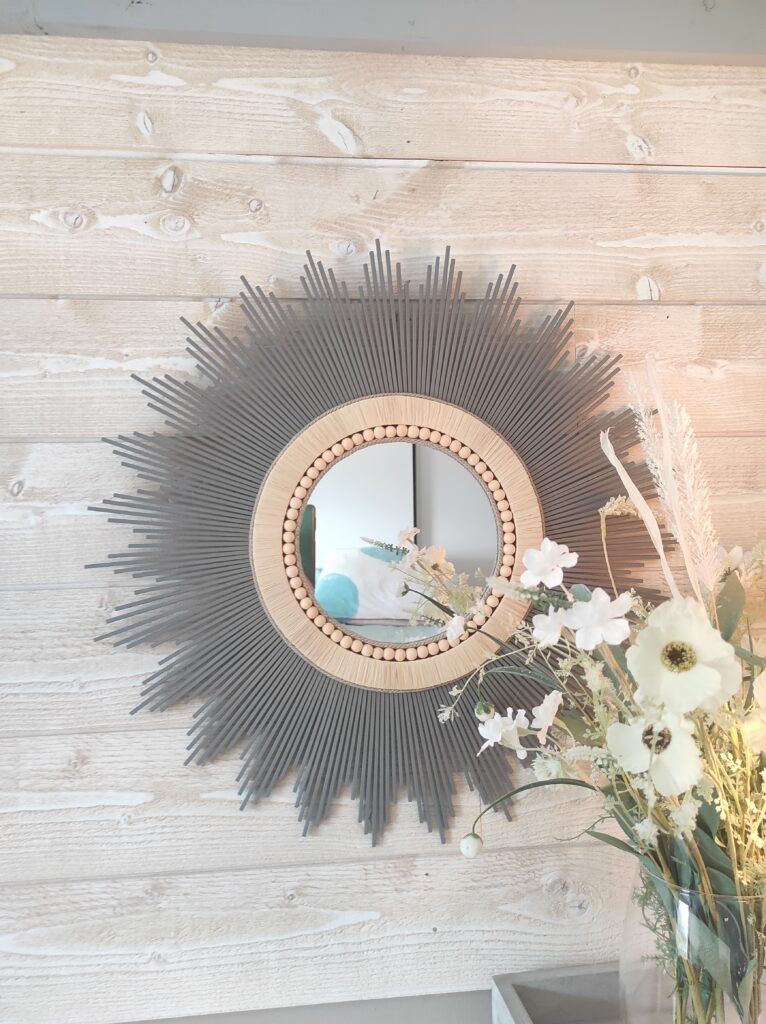 Création française, miroir rond en bois teinté d’un gris tendance, d’un bord en raphia et de perles de bois Ju0231