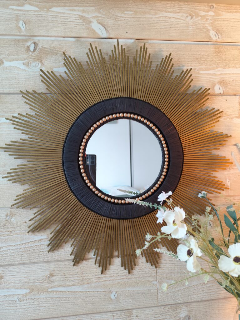 Décoration soleil.Miroir rond en bois teinté or antique, cerné de raphia tressé noir.Ju0252