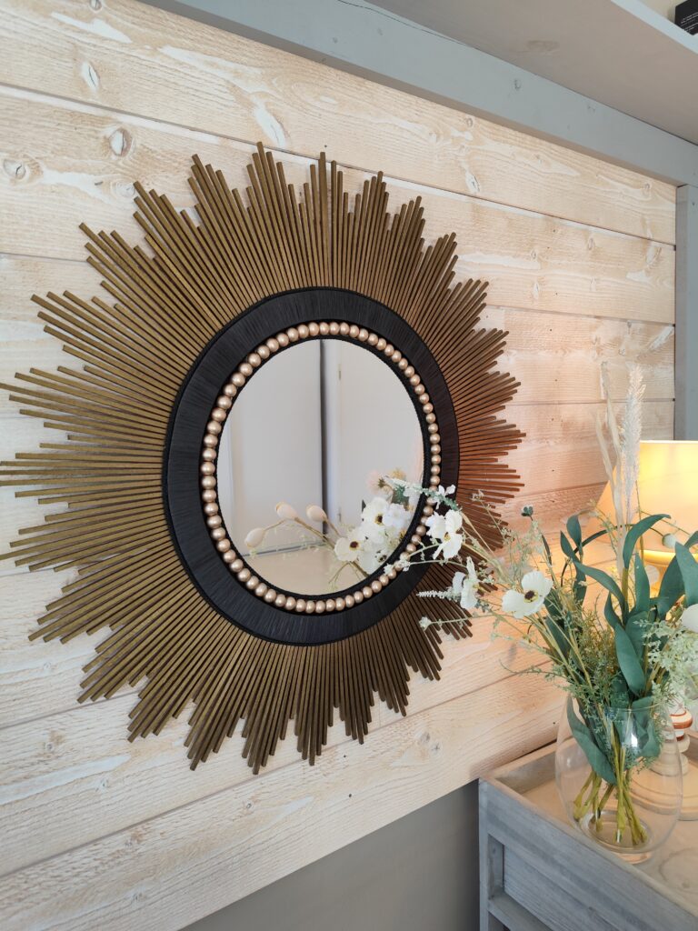 Décoration soleil.Grand miroir rond en bois teinté or antique, cerné de raphia tressé noir.Ju0268