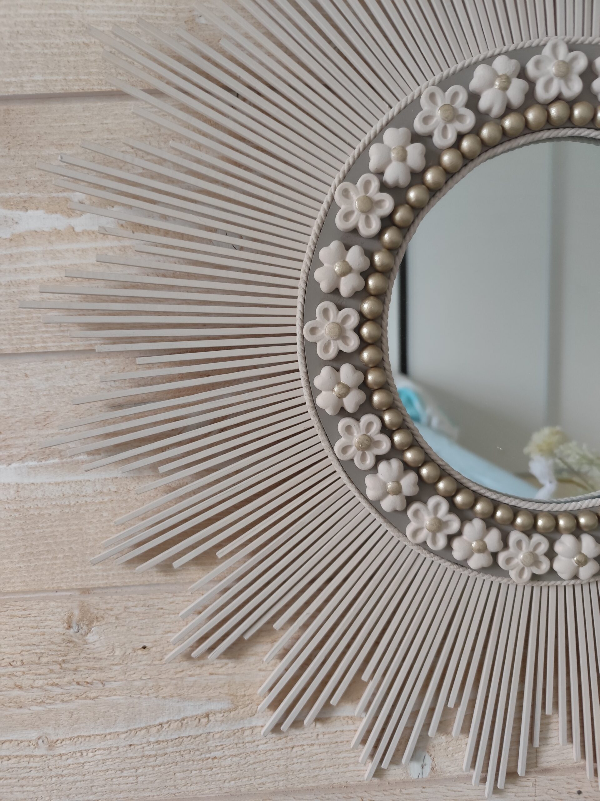 Décoration soleil.Miroir rond en bois teinté lin, cerné d’éléments déco et de perles or.Ju0272