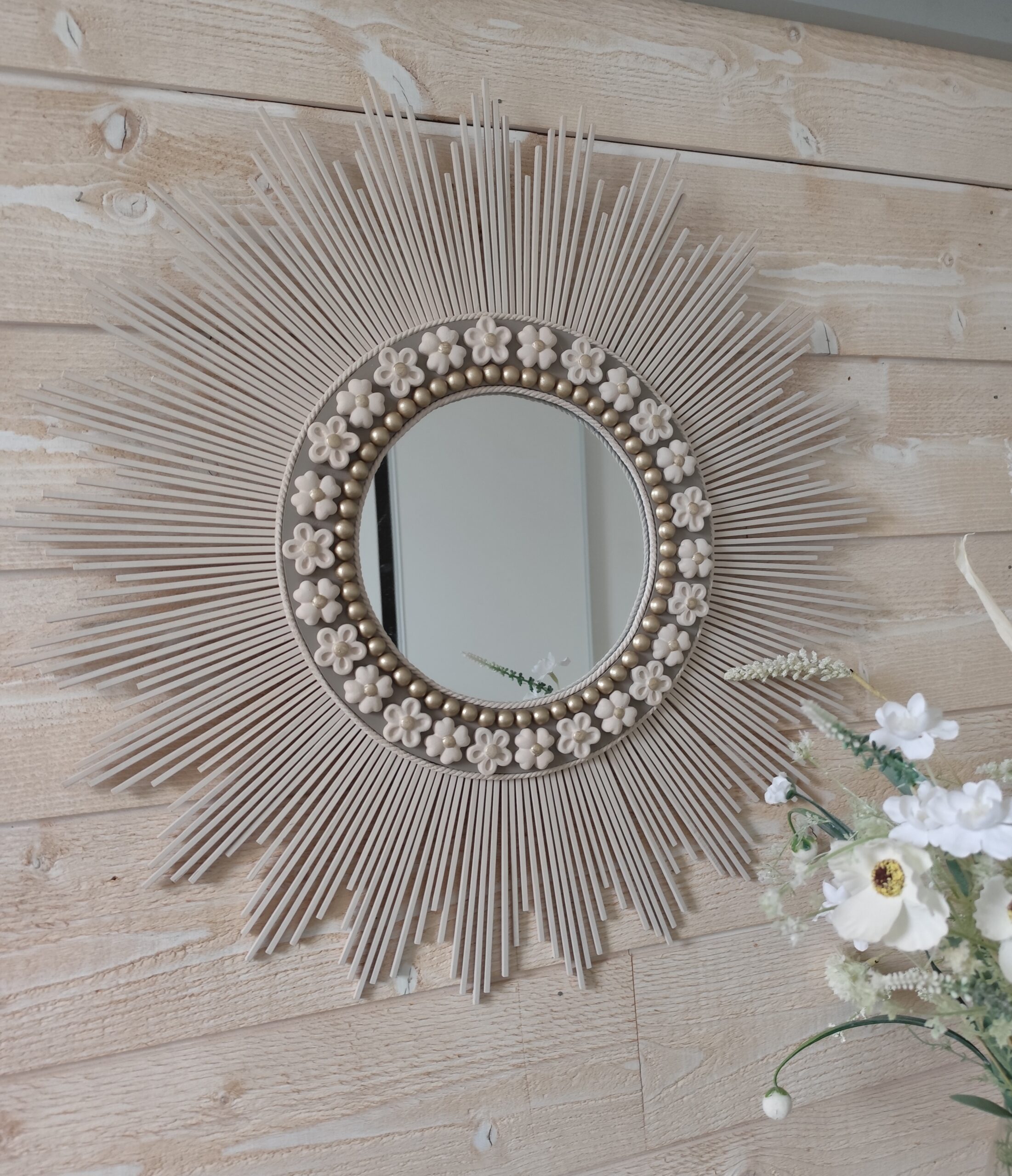 Décoration soleil.Miroir rond en bois teinté lin, cerné d’éléments déco et de perles or.Ju0272