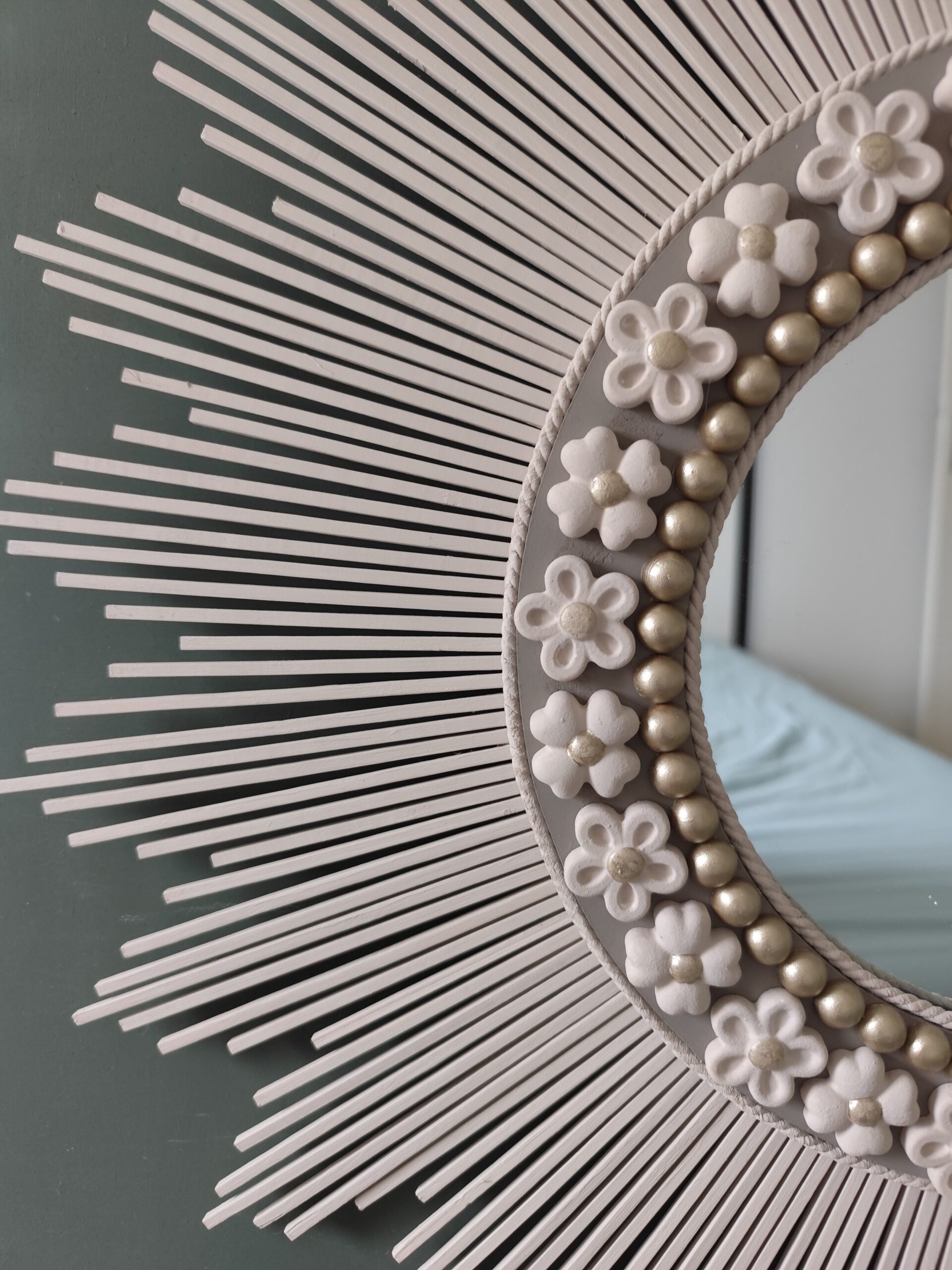 Décoration soleil.Miroir rond en bois teinté lin, cerné d’éléments déco et de perles or.Ju0272