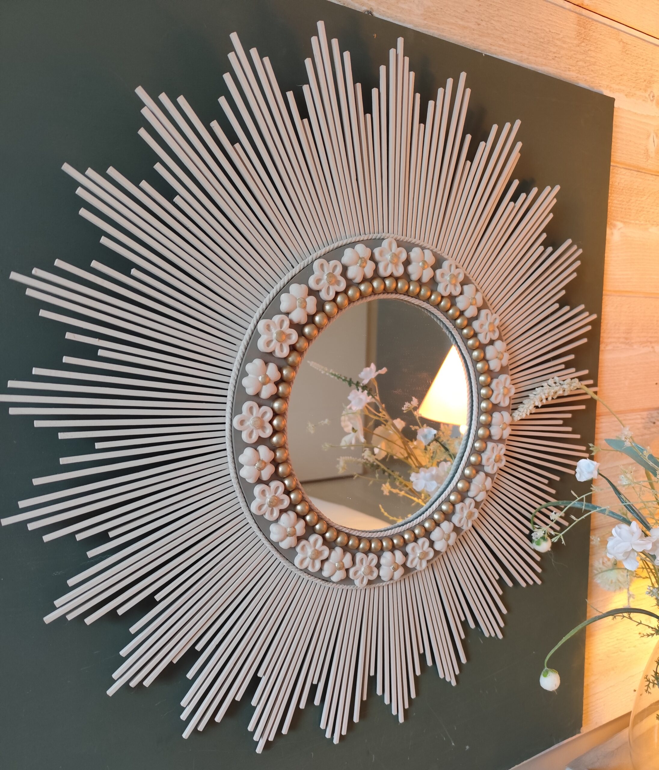 Décoration soleil.Miroir rond en bois teinté lin, cerné d’éléments déco et de perles or.Ju0272