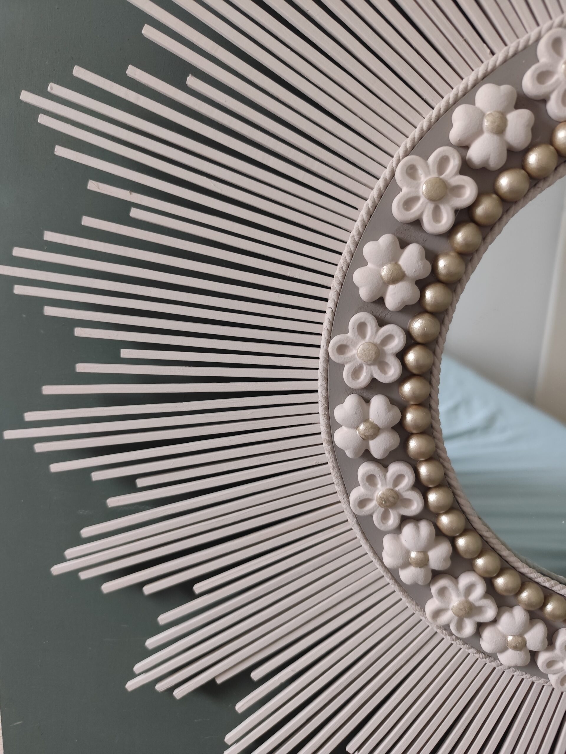 Décoration soleil.Miroir rond en bois teinté lin, cerné d’éléments déco et de perles or.Ju0272