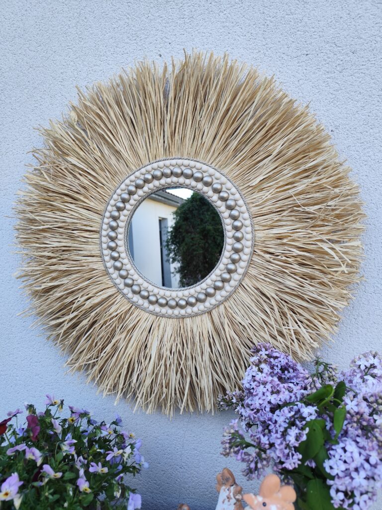 Miroir rond en raphia naturel, cerné de cordes de lin et de perles de bois.Réf Ju0274