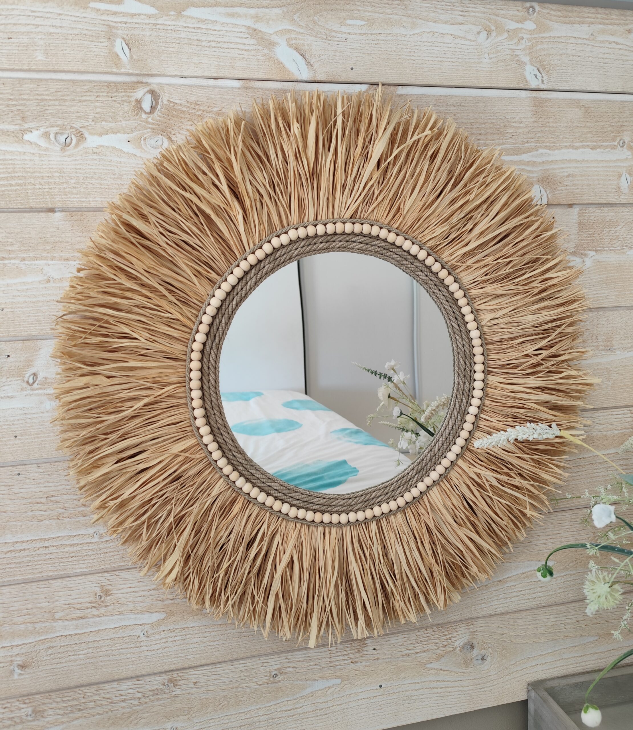 Miroir rond en raphia naturel, cerné de cordes de lin et de perles de bois.Réf Ju0276