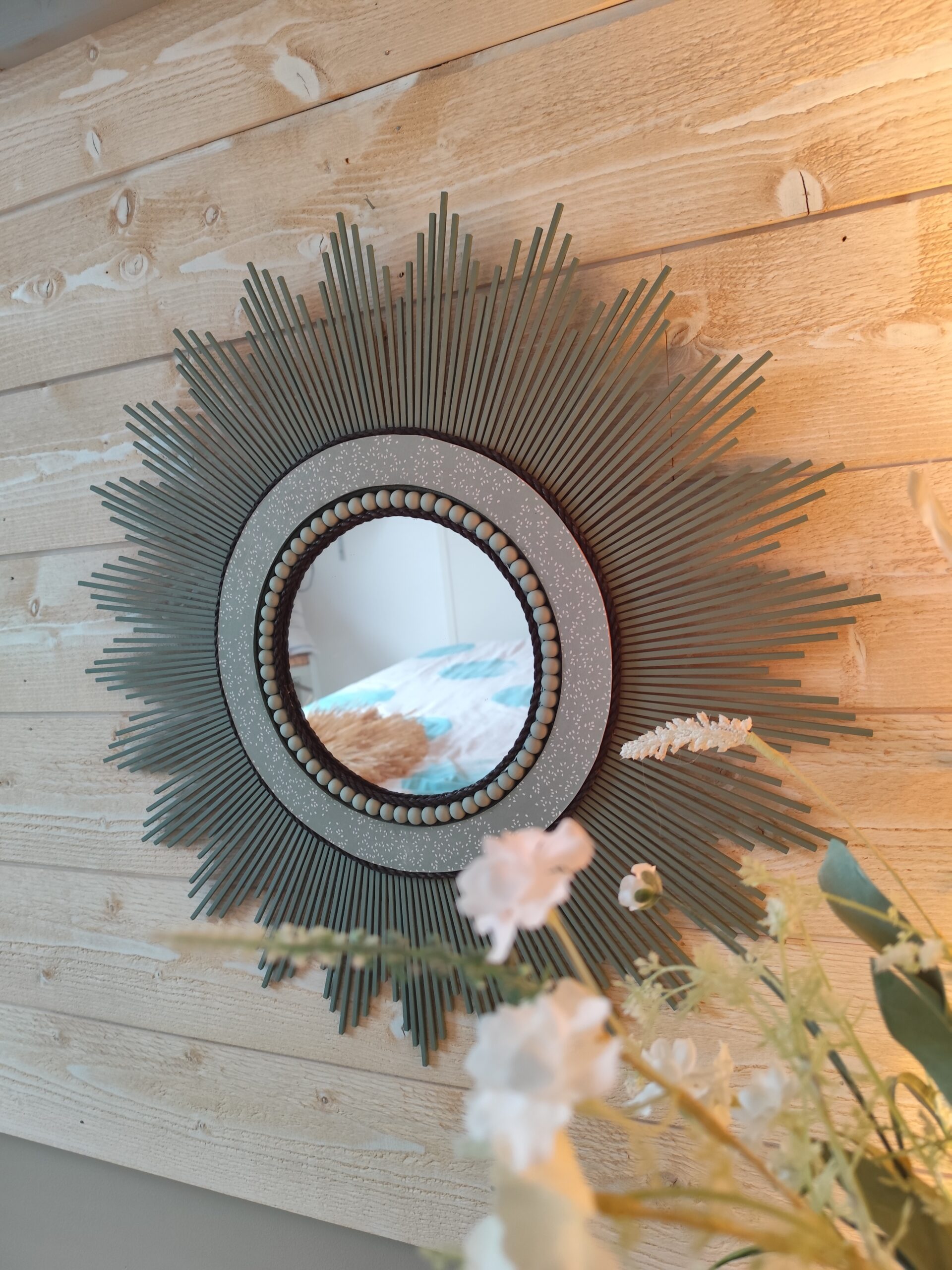 Décoration soleil.Miroir rond en bois teinté vert sauge, cerné d’éléments déco et de perles en bois.Ju0278