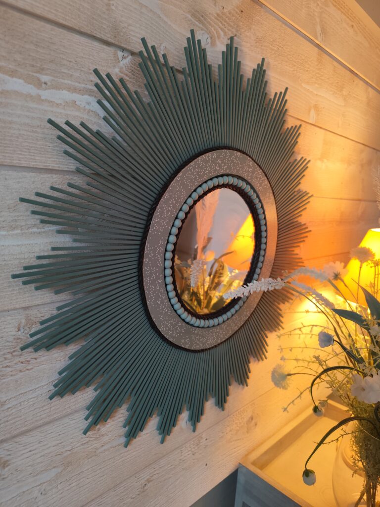 Décoration soleil.Miroir rond en bois teinté vert sauge, cerné d'éléments déco et de perles en bois.Ju0278