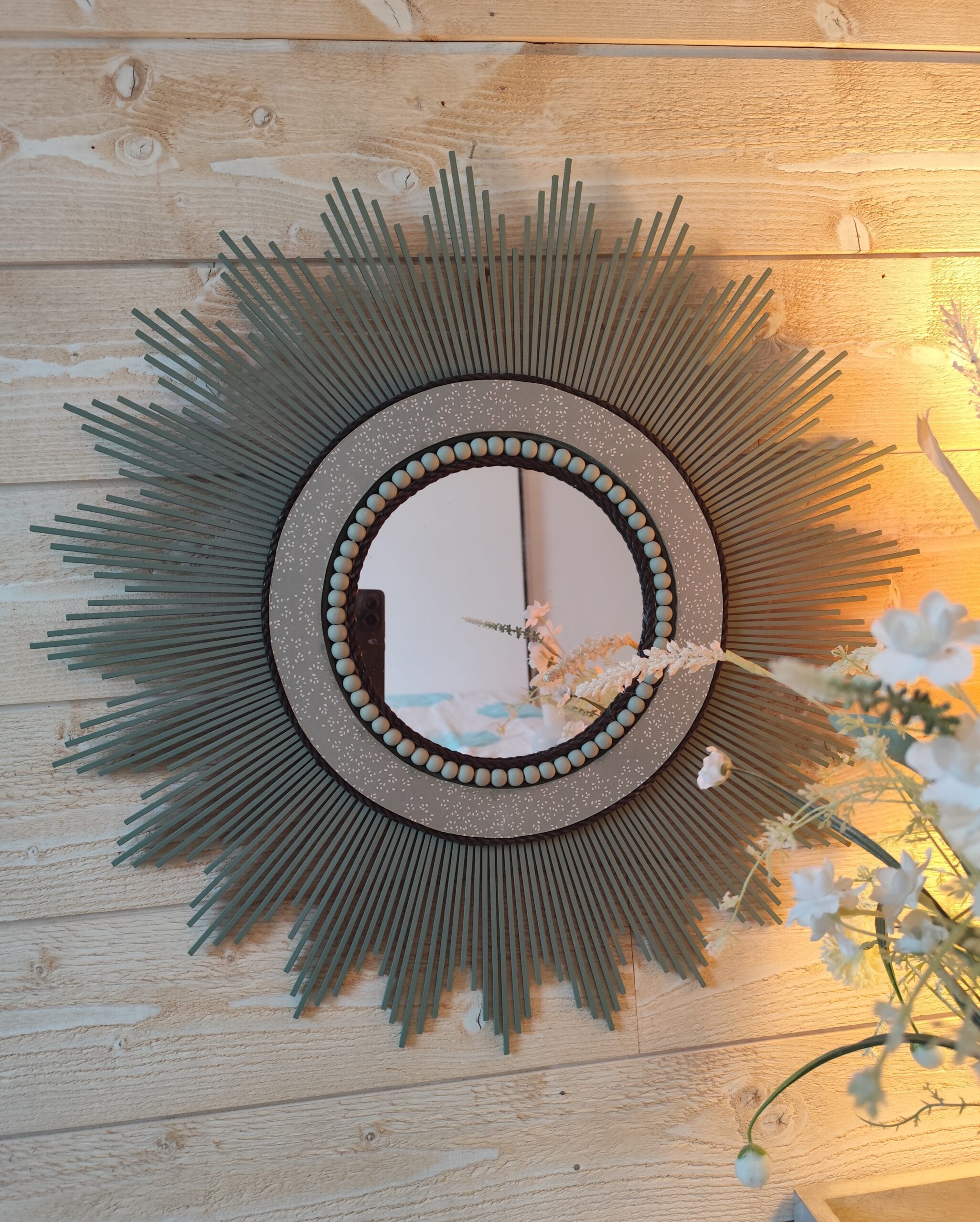 Décoration soleil.Miroir rond en bois teinté vert sauge, cerné d’éléments déco et de perles en bois.Ju0278